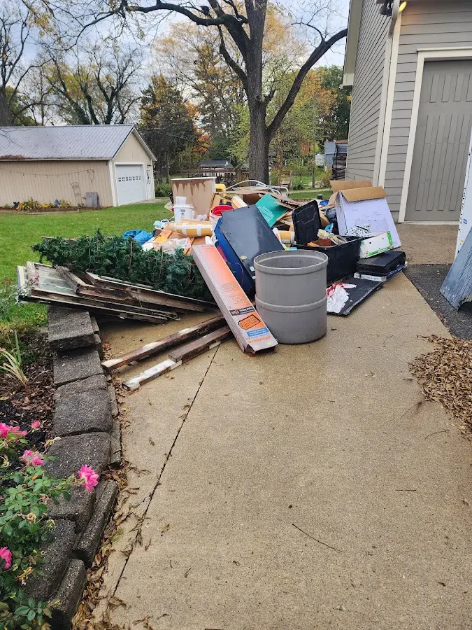 Dumpster being loaded with debris for 12 Yard Dumpster Rental in Three Lakes